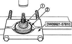 Использование приспособления DW 09921—57810 для снятия левого подшипника (1) вторичного вала и шестерни пятой передачи (2)