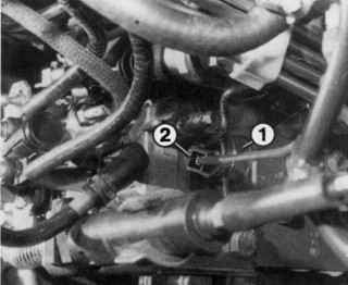 Расположение разъема (2) электромагнитного клапана (1) остановки двигателя
